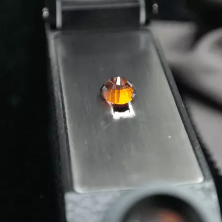 Picture of an orange gem in a refractometer